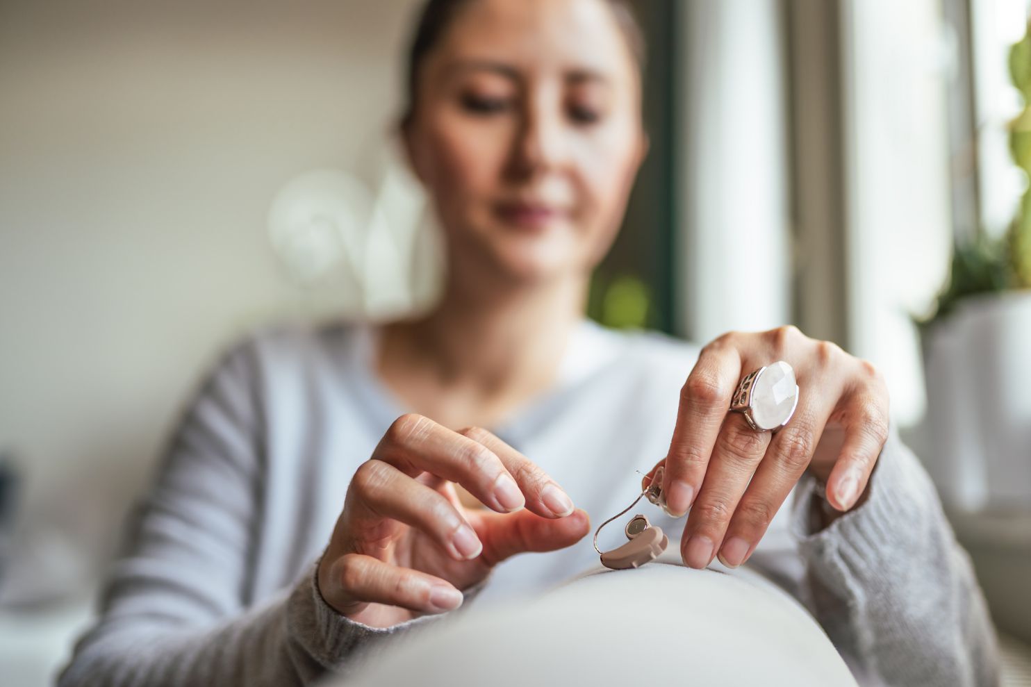 woman changing hearing aid batteries